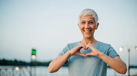 Active senior woman making a heart with her hands