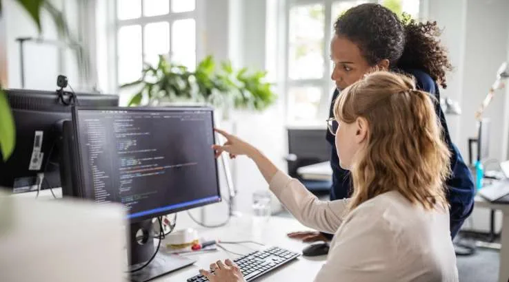 Female colleagues discussing coding problem