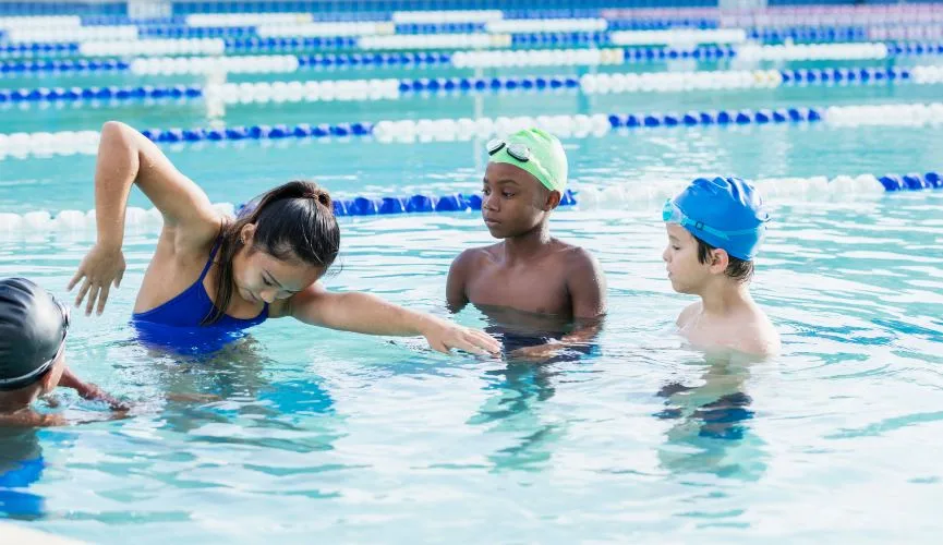 Image: Getty Images woman giving swimming lessons to kids