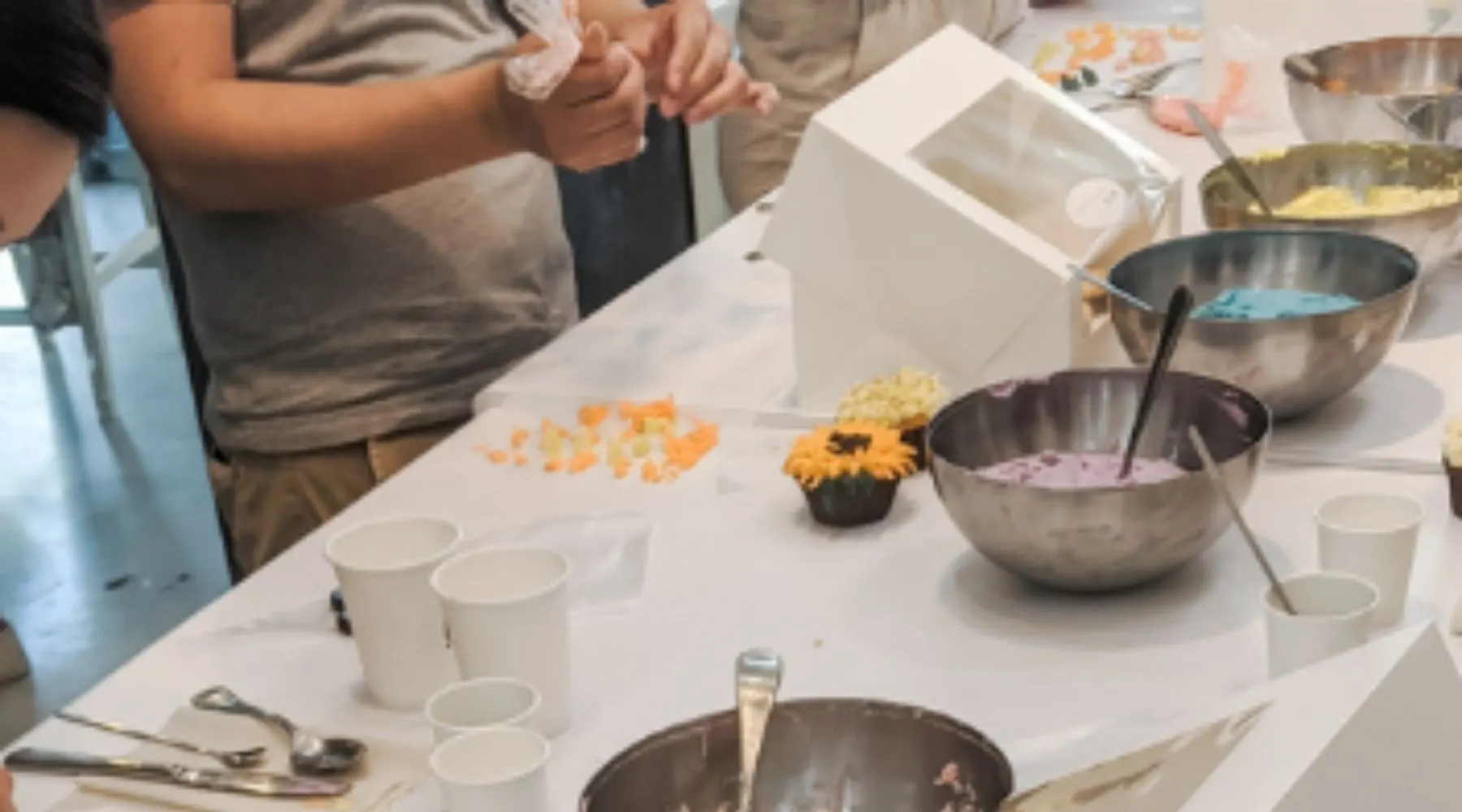 People take part in a cupcake making class.