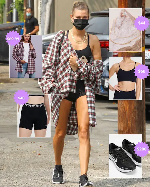 Hailey Bieber wearing black shorts, sports bra, a flannel shirt and Nike runners.