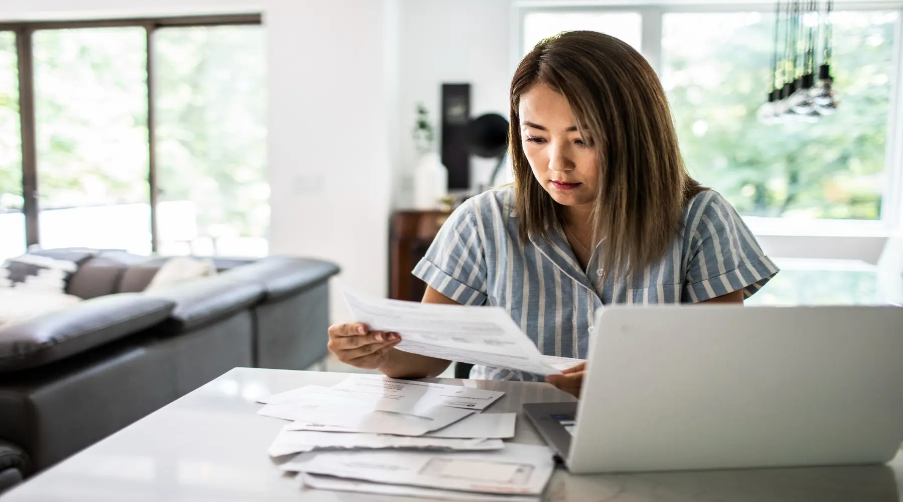 Woman with bills_GettyImages_1800x1000