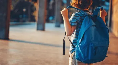 School aged child with blue backpack