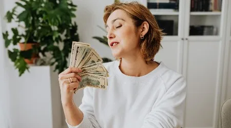 A woman fanning herself with money. 