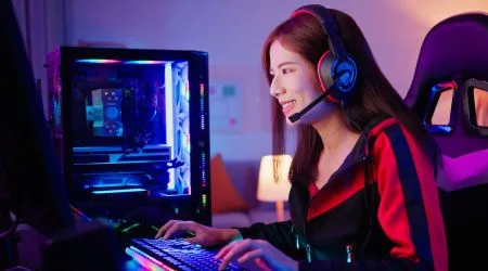 Woman gaming online with a multi-colour LED gaming tower