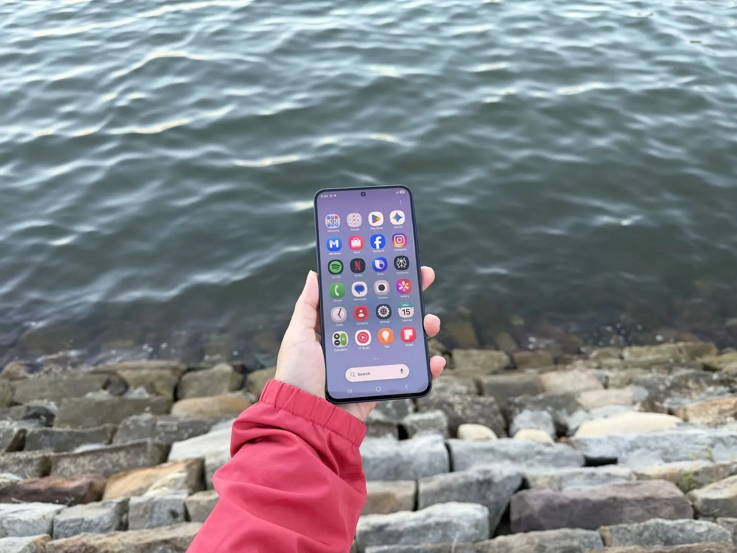 A person holding Samsung Galaxy A57 that displays the front screen and features of the device.