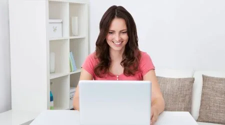 A woman checking her savings on her laptop