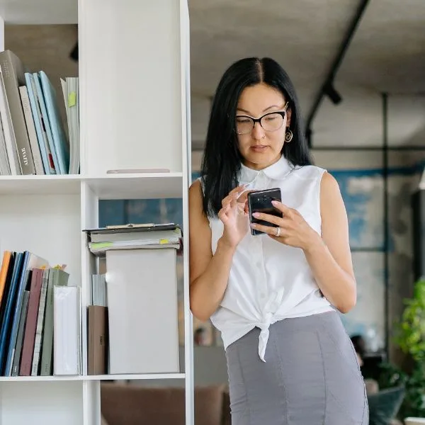 A business owner sending a text in her office