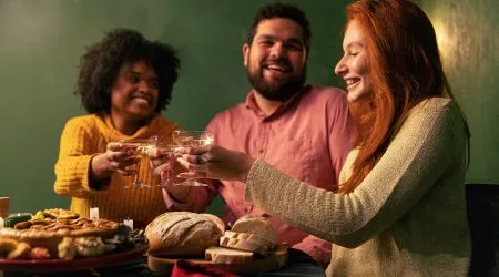 Two women and one man raising their glass.