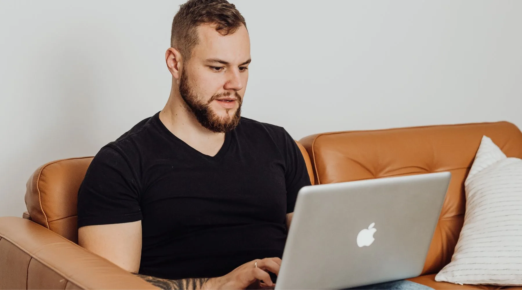 Man_Trading_On_Laptop_Sitting_Brown_Couch_Canva_1800x1000