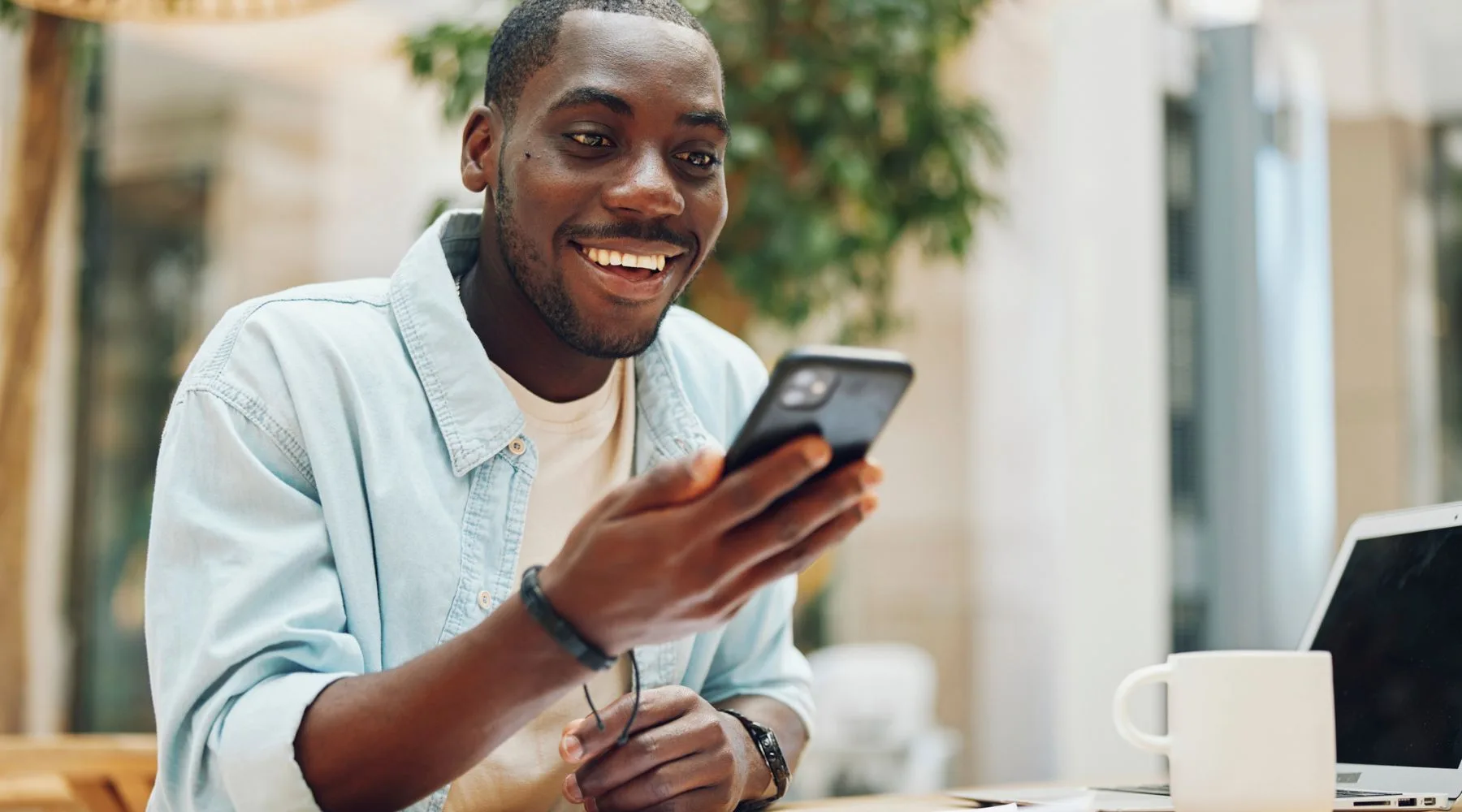 Young_Man_Trading_On_Phone_Canva_1800x1000 Young_Man_Trading_On_Phone_Canva_1800x1000