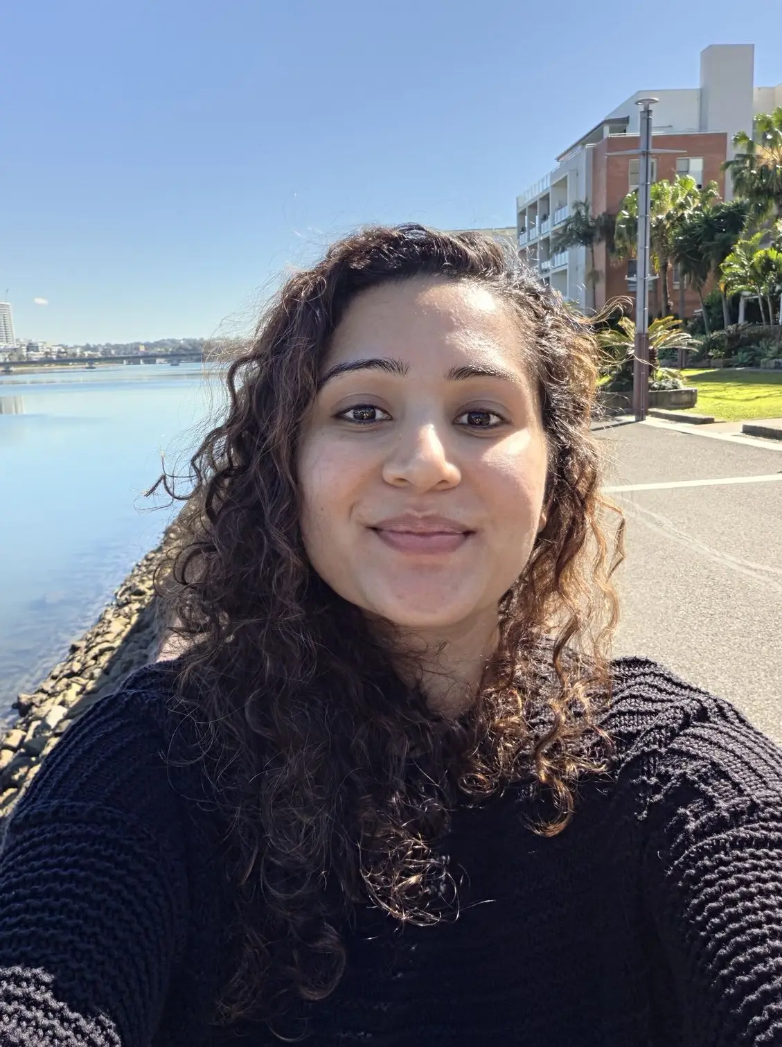 Another daylight selfie sample from the Samsung Galaxy Z Fold 8, capturing natural skin tones and sharp background detail along a riverside promenade. 