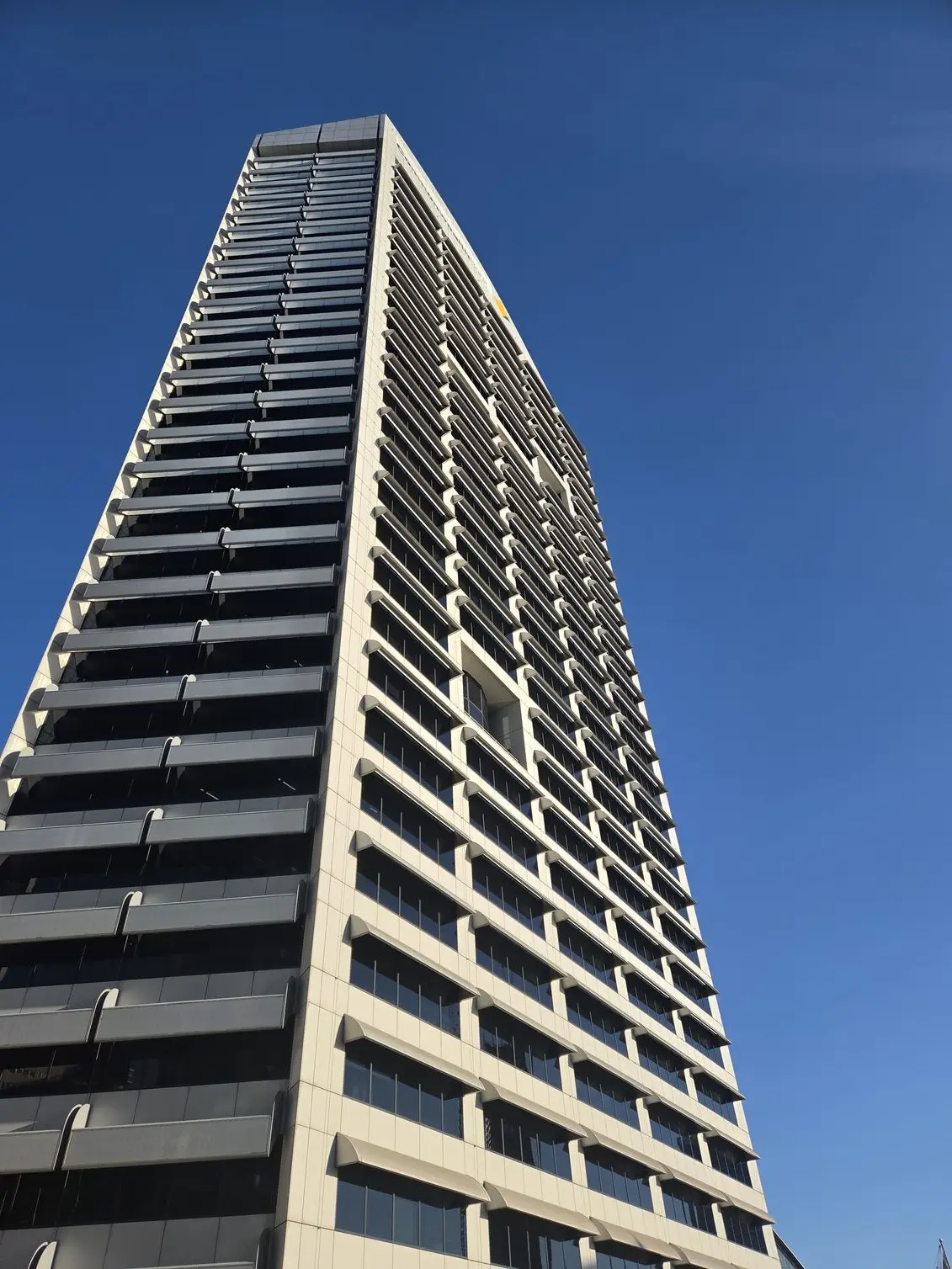 An upward-angle shot of a high-rise tower, demonstrating how the Samsung Galaxy Z Fold 8's ultra-wide lens handles sharp architectural lines and a clean blue sky. 