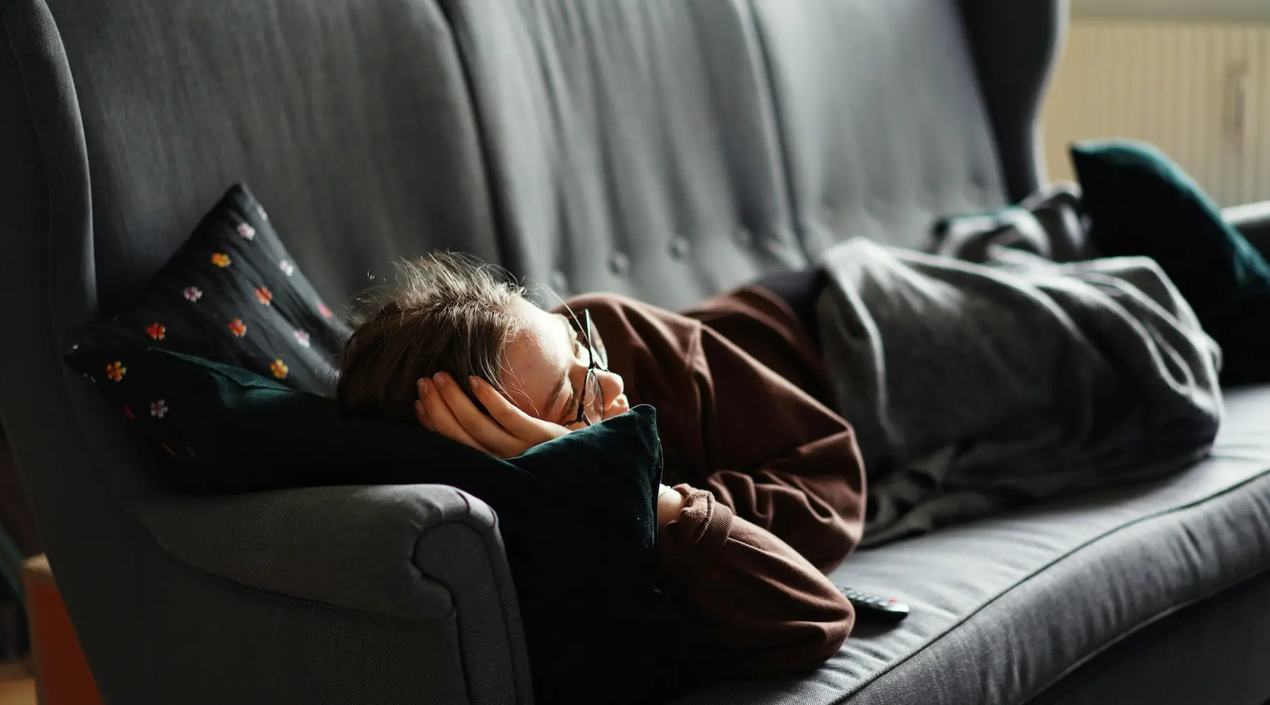 Young woman lying down watching TV streaming_Unsplash_1800x1000