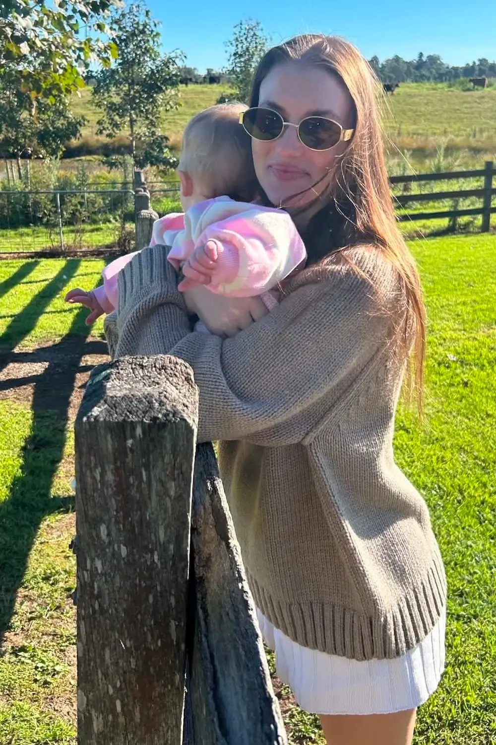 Image: Supplied Young mum Peta Taylor holding her baby and leaning against a fence