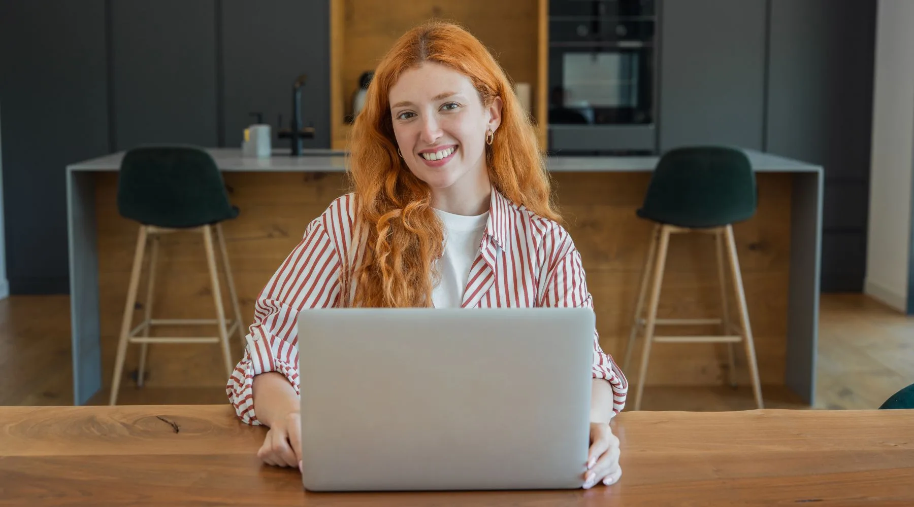 Redhead_Woman_Using_Laptop_At_Desk_Canva_1800x1000 Redhead_Woman_Using_Laptop_At_Desk_Canva_1800x1000